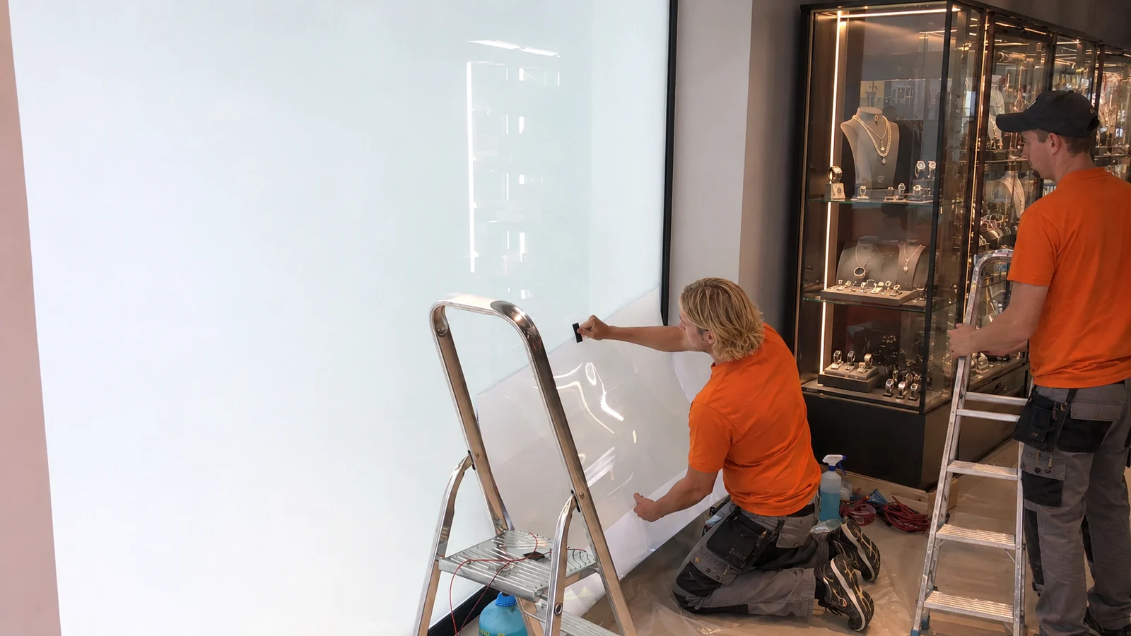Installer applying PDLC smart film on commercial glass for a SmartGlass USA privacy project